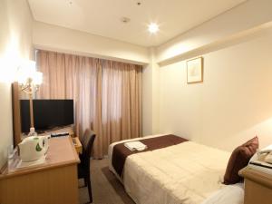 佐世保市にあるSunwest Hotel Sasebo - Vacation STAY 22075vのベッド、デスク、コンピュータが備わるホテルルームです。