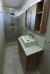 La salle de bains est pourvue d'un lavabo et d'une douche. dans l'établissement Chez Diana, à Flic-en-Flac