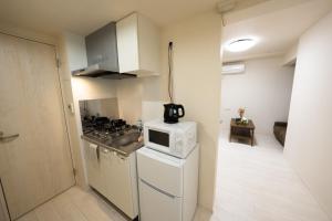 a small kitchen with a stove and a microwave at FL Rejidence Shinjuku 2 - Vacation STAY 15201 in Tokyo