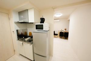 a kitchen with a microwave on top of a refrigerator at FL Rejidence Shinjuku 2 - Vacation STAY 15200 in Tokyo