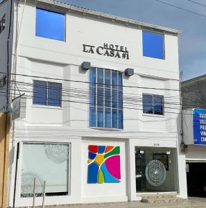 un edificio blanco con un cartel. en Hotel La Casa 1, en Montería