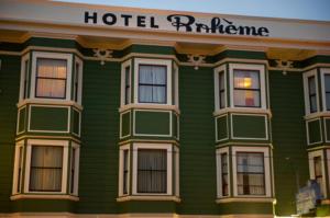 un bâtiment d'hôtel vert avec un panneau variant sur celui-ci dans l'établissement Hotel Boheme, à San Francisco