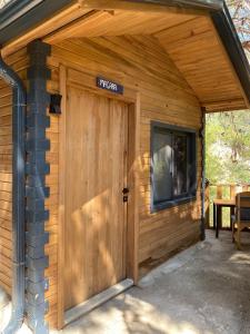 a wooden garage door with a sign on it at Reflections Camp in Faralya