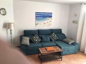 a living room with a blue couch and a table at El Carmen in El Cotillo