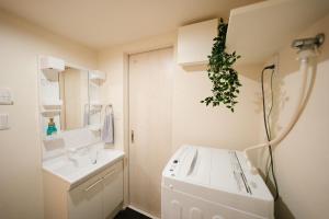 a white bathroom with a sink and a mirror at FL Rejidence Shinjuku 2 - Vacation STAY 15187 in Tokyo