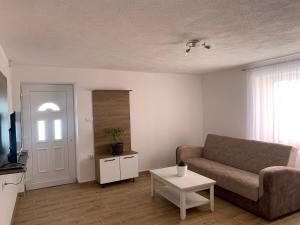 - un salon avec un canapé et une table dans l'établissement Lejla's guesthouse, à Gusinje