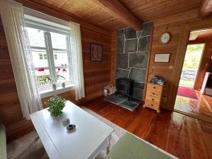 a living room with a fireplace in a log cabin at Drengastova Hardangerfjord in Lofthus