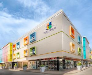 a large white building with a store front at Hotel Americas San Andres Islas Colombia in San Andrés