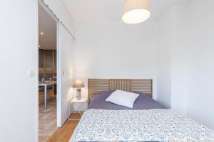 a white bedroom with a bed and a desk at Antipolis in Cros-de-Cagnes