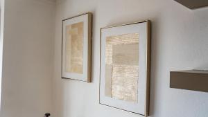 deux images encadrées d'une fenêtre sur un mur dans l'établissement Lush Studio Apartment with Back-Up Power., à Sandton