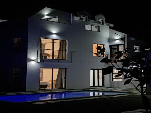 a house at night with a swimming pool in front of it at 6 on Third in Stompneusbaai