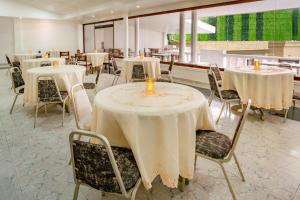 a dining room with tables and chairs with candles on them at Hotel Americas San Andres Islas Colombia in San Andrés