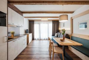 una cucina e una sala da pranzo con tavolo in una stanza di Apartments Roda de Ciar a Badia