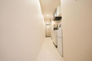 a hallway with white walls and a white refrigerator at FL Rejidence Shinjuku 2 - Vacation STAY 15191 in Tokyo