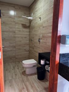 a small bathroom with a toilet and a shower at JOTA Área de Lazer in Dourados