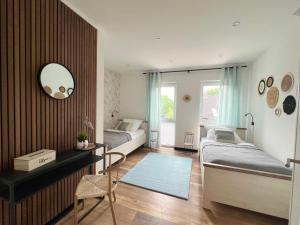 a bedroom with two beds and a desk and a mirror at Große Wohnung Wellness + Sauna + Netflix in Petershagen