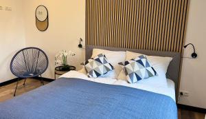 a bedroom with a bed with a blue blanket and pillows at Große Wohnung Wellness + Sauna + Netflix in Petershagen