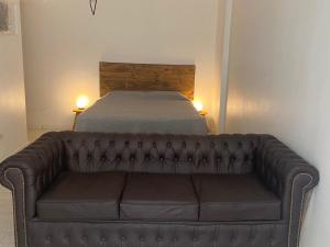 un sofá de cuero en una habitación con cama en APART.CANTILO en Buenos Aires