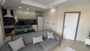 a living room with a couch and a kitchen at GAZİPAŞA SELİNTİ CİTY DUBLEX 2 Oda in Gazipasa