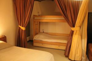 a bedroom with a bunk bed with curtains at Hof Gensterbloem 