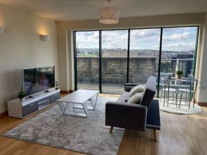 uma sala de estar com um sofá, uma televisão e uma mesa em 2 Bedroom Stunning Penthouse city view em Bradford