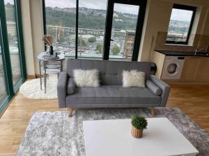uma sala de estar com um sofá com almofadas em 2 Bedroom Stunning Penthouse city view em Bradford