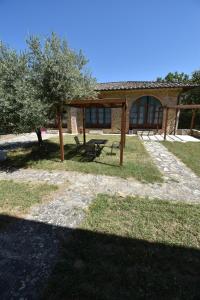 una casa con una mesa de picnic y un árbol en Borgo Mulignone, en Casole dʼElsa