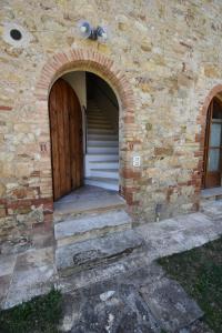 una entrada a un edificio de piedra con puerta de madera en Borgo Mulignone, en Casole dʼElsa