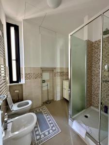 La salle de bains est pourvue d'une douche, de toilettes et d'un lavabo. dans l'établissement Due Passi dal Porto, à Gênes