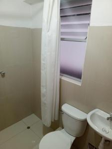 uma casa de banho com um WC, um lavatório e uma janela em DEPARTAMENTO AMOBLADO EN CUSCO em Cusco