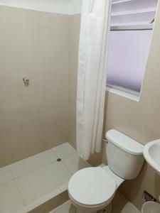 een witte badkamer met een toilet en een wastafel bij DEPARTAMENTO AMOBLADO EN CUSCO in Cuzco