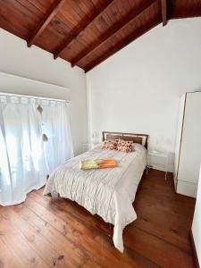 a bedroom with a bed and a wooden floor at Complejo Alberdi depto 8 in Tandil