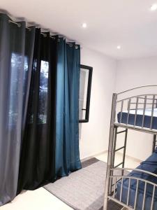 um quarto com cortinas azuis e um beliche em Maison centre-ville em Penta-di-Casinca