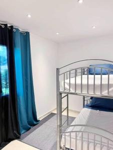 een slaapkamer met een stapelbed en blauwe gordijnen bij Maison centre-ville in Penta-di-Casinca