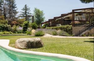 una gran roca sentada en el césped junto a un edificio en Finca LaGloria, en Guadarrama