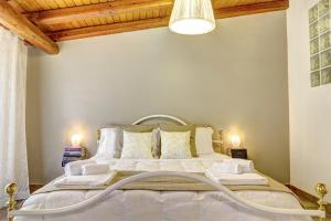 a bedroom with a white bed with two lamps at Zina Suite Apartment in Giardini Naxos