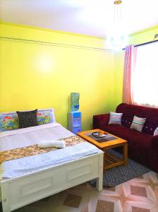1 dormitorio con cama, sofá y mesa en Devine 1 bedroom on Moi Southlake road en Naivasha