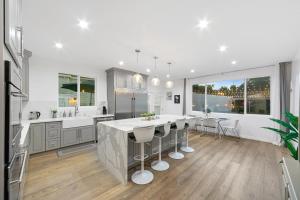 una cocina con una gran isla con taburetes de bar en Studio City Contemporary Villa with Pool Sleeps 10 en Los Ángeles