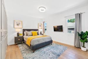 a white bedroom with a bed and a window at Studio City Contemporary Villa with Pool Sleeps 10 in Los Angeles