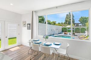a dining room with a table and chairs and a large window at Universal Studios Villa with Pool & Guesthouse in Los Angeles