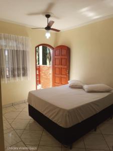Schlafzimmer mit einem Bett und einem Deckenventilator in der Unterkunft Chácara Vicente Gazzi in Socorro