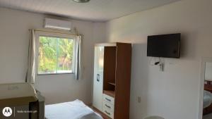 ein Schlafzimmer mit einem Bett und einem TV an der Wand in der Unterkunft Residencial Dom Fernando in Belém