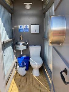 a small bathroom with a toilet and a sink at Gresham Hall Glamping in Aylmerton