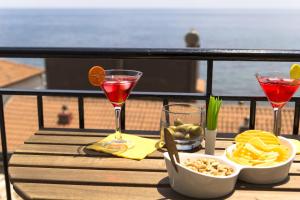a table with two drinks and snacks on a balcony at Zina Suite Apartment in Giardini Naxos