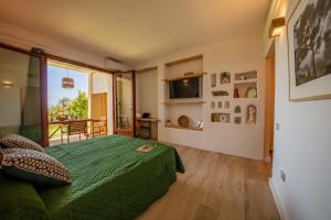 a bedroom with a green bed and a large window at Sweet Life in Golf Is Molas in Pula