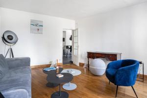 sala de estar con sofá y silla azul en Superb flat in the heart of Montmartre - Welkeys en París