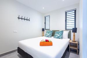 a white bed with a basket of flowers on it at Coral Estate Ocean View Apartments in Willemstad