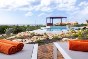 a couple of towels sitting on a table next to a pool at Coral Estate Ocean View Apartments in Willemstad