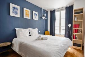 un dormitorio con una cama con un animal de peluche en Superb flat in the heart of Montmartre - Welkeys en París