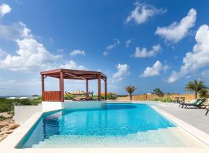 a swimming pool with a gazebo next to a villa at Coral Estate Ocean View Apartments in Willemstad